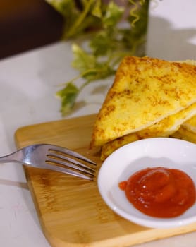Fresh fried delicious french toast sandwich with cheese filling plated in white plate, just freshly fried in the restaurant
