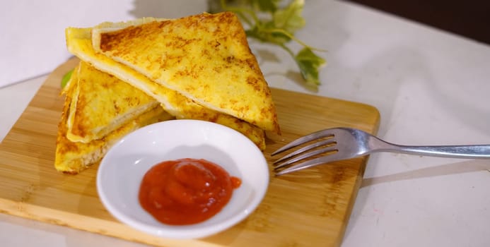 Fresh fried delicious french toast sandwich with cheese filling plated in white plate, just freshly fried in the restaurant