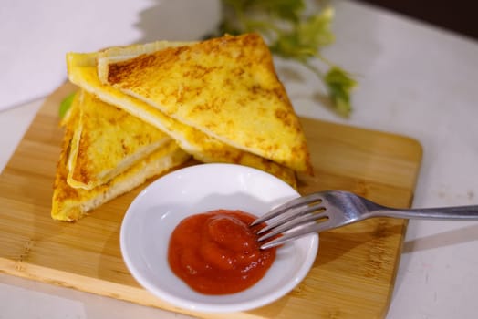 Fresh fried delicious french toast sandwich with cheese filling plated in white plate, just freshly fried in the restaurant