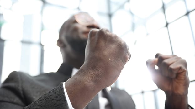 A businessman man in a close-up in a jacket in the office, he rejoices at a successful deal.