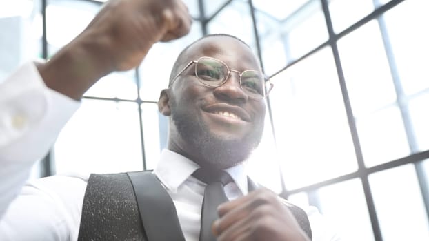 A businessman man in close-up in a shirt in the office, he rejoices at a successful deal.