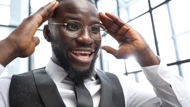 A businessman man in close-up in a shirt in the office, he rejoices at a successful deal.