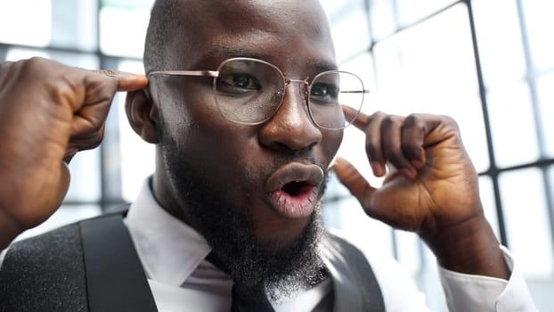 A businessman man in close-up in a shirt in the office, he rejoices at a successful deal.