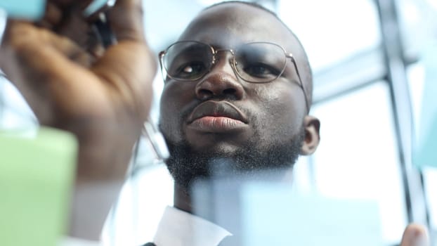 A businessman man in close-up in a shirt in the office is thinking over a plan.