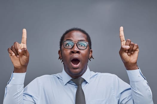 young african american man surprised showing fingers up on gray background.
