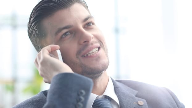 A successful businessman is talking on the phone.