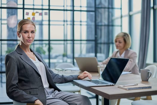 Businesswoman working at her office desk with documents and laptop