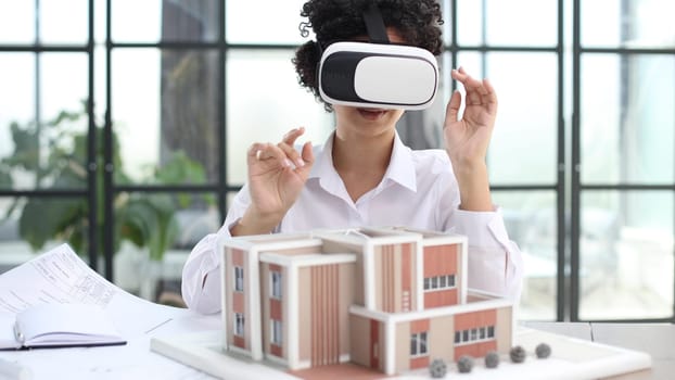 female architect designer examines house layout with 3d glasses at office