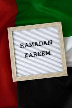 Congratulations with text RAMADAN KAREEM - happy holidays waving UAE flag on background concept. Greeting card advertisement. Commemoration Day Muslim Blessed holy month public holiday