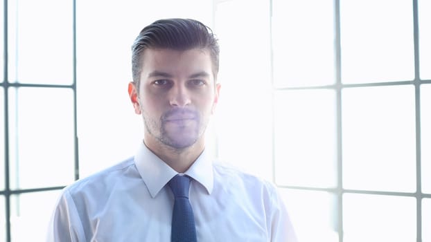 Male businessman in close-up looks at the camera.
