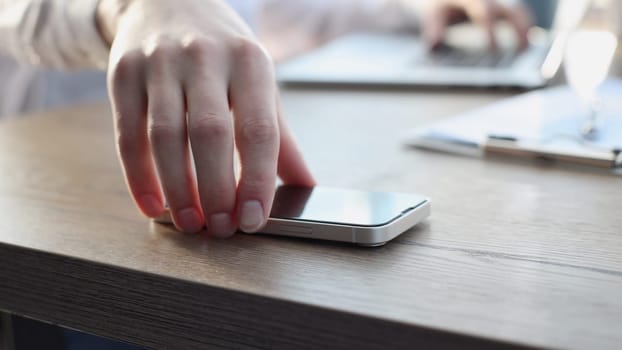 A businessman man in close-up in a shirt takes the phone.