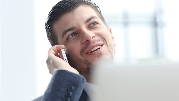 A male businessman is talking on the phone and negotiating a deal.