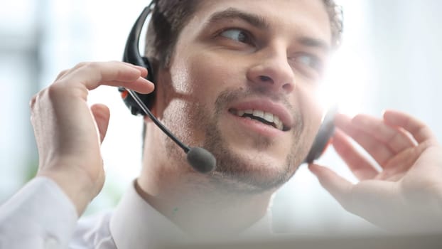 An office worker contacts and talks to a client with headphones.