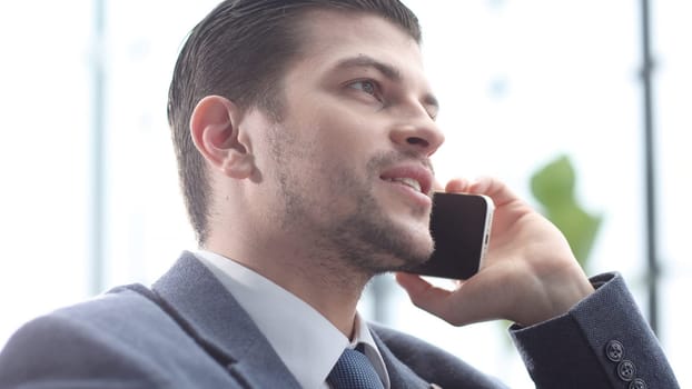 A male businessman is talking on the phone and negotiating a deal.