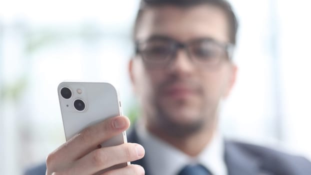 A male businessman uses a phone in close-up.