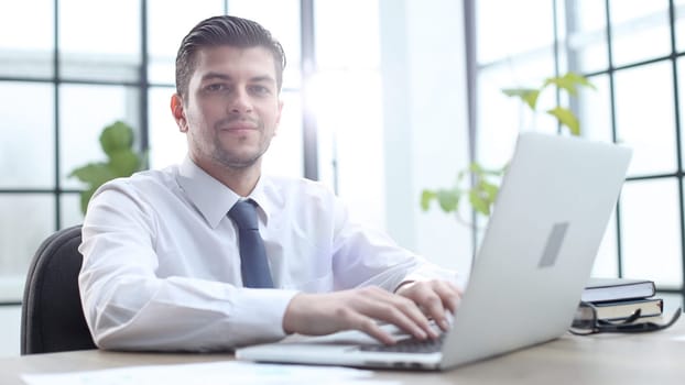 Male businessman in close-up working on a laptop.