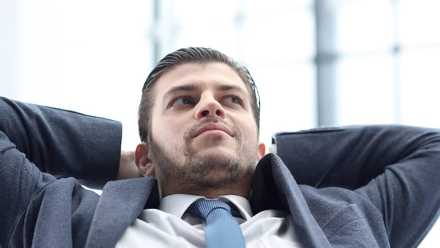 The businessman is tired and resting at his workplace.