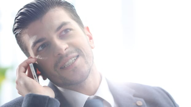 A successful businessman is talking on the phone.