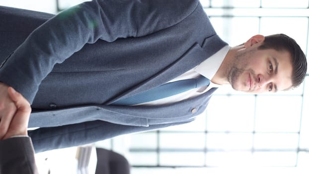 A businessman man shakes hands with a colleague in close-up.