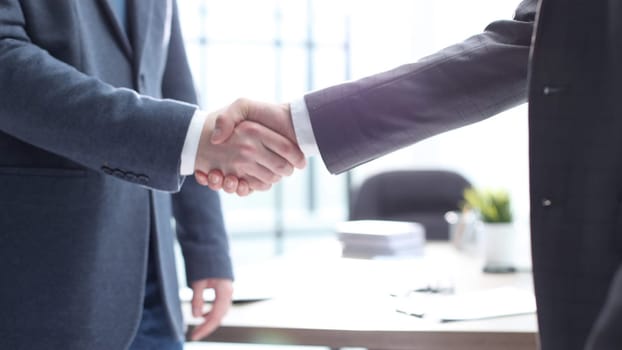Businessmen shake hands in the office.