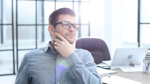 A male office worker looks at the camera in close-up.