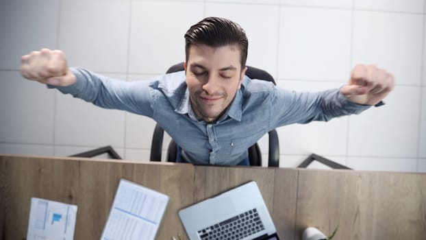 A male office worker is tired and warming up.