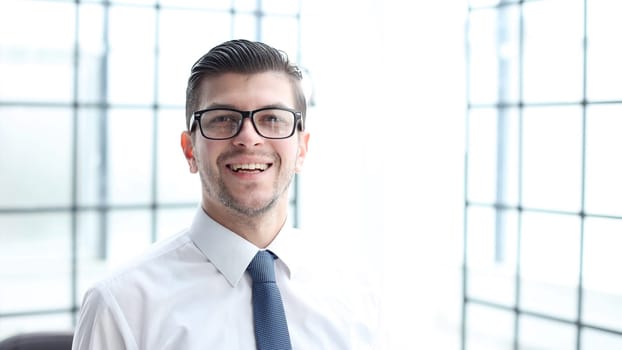A male office worker looks at the camera in close-up.