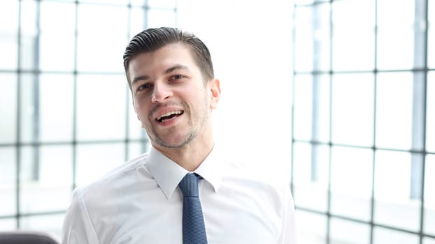 A male office worker looks at the camera in close-up.