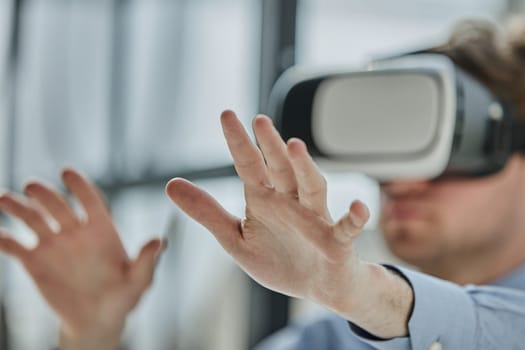 young man testing VR glasses or goggles sitting in the office room