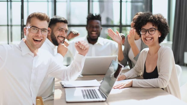 Portrait of successful creative business team looking at camera and smiling. Diverse business people standing together at startup.