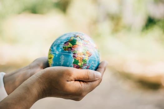 Mark World Earth Day with the concept of Green Energy ESG and Environmental Social and Corporate Governance. Embrace a green leaf and the globe in your hand symbolizing responsibility and global care.