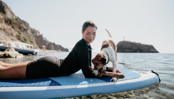 Sea woman sup. A happy positive woman in hat with family relaxing in sea, aerial back view of family on SUP board floating on calm water. Active lifestyle at sea. Summer vacation. Slow motion