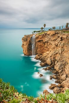 Long exposure image of the waterfall falling from the cliffs into the sea in Fener, Antalya