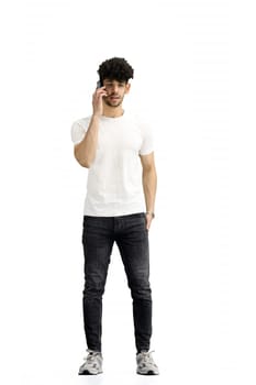 A man, on a white background, in full height, with a phone.