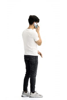 A man, on a white background, in full height, with a phone.