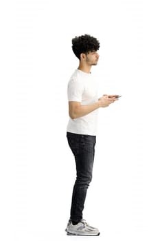 A man, on a white background, in full height, with a phone.