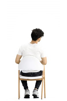 A man, on a white background, is sitting on a chair, with phone.