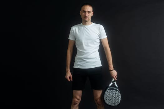 Beautiful man playing paddle tennis, racket in hand concentrated look. Young sporty boy ready for the match. Focused padel athlete ready to receive the ball. Sport, health, youth and leisure concept. High quality photo