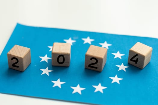 European Union vote, 2024 on wooden blocks against the background of the EU flag, the concept of voting and taking part in the European elections. High quality photo