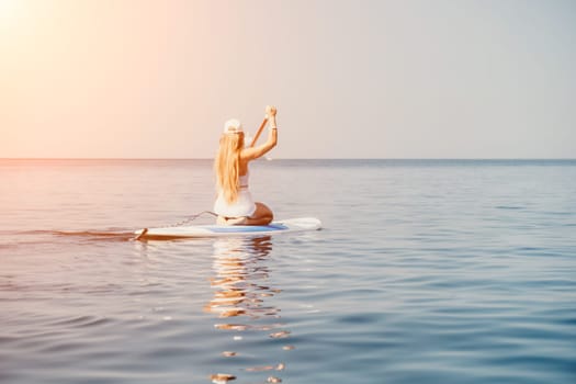 Close up shot of beautiful young caucasian woman with black hair and freckles looking at camera and smiling. Cute woman portrait in a pink bikini posing on a volcanic rock high above the sea