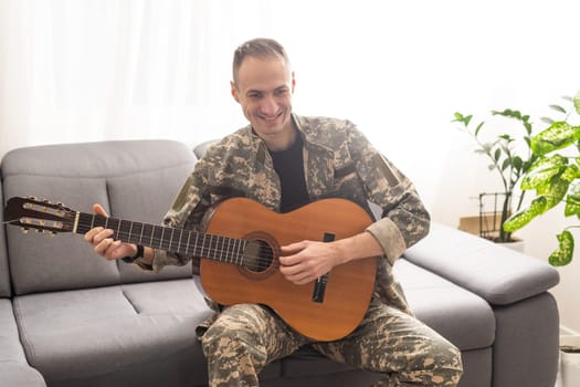 Veteran Guitar Play Concept. Family Meeting. Camouflage Uniform. Resting Together. Feelings Showing. Patriotic Comeback. Paralyzed Soldier. High quality photo