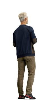 A man, full-length, on a white background, uses a phone.