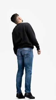 A man, full-length, on a white background, looks into the distance.