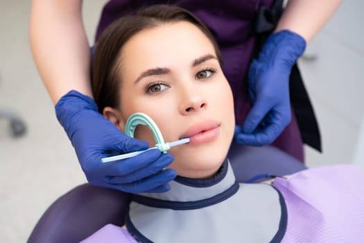 Process of preparation of patient before dental X-ray procedure. Woman instructs patient on how to tilt head before dental X-ray procedure