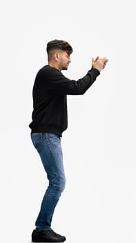 A man, full-length, on a white background, claps.