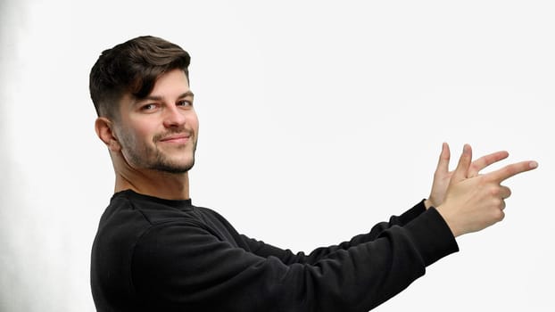A man, close-up, on a white background, points to the side.