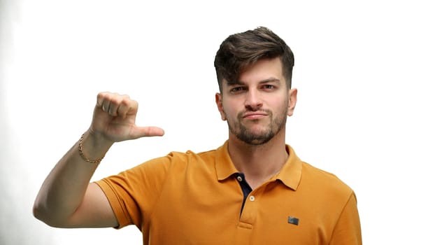 A man, close-up, on a white background, shows his finger down.