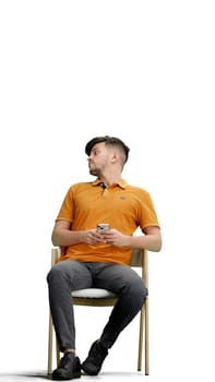 A man, full-length, on a white background, sitting on a chair.