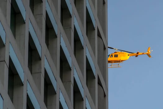 yellow Helicopter looks like crashing on skyscraper