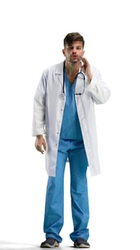 The doctor, in full height, on a white background, tells a secret.